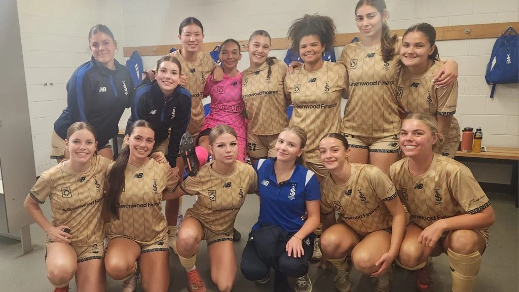 Sydney Olympic FC U18 Girls squad together in the dressing room in their gold away kit